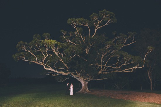 bride and groom under tree at night