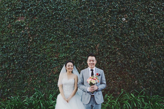 Bride and groom in front of ivy wall