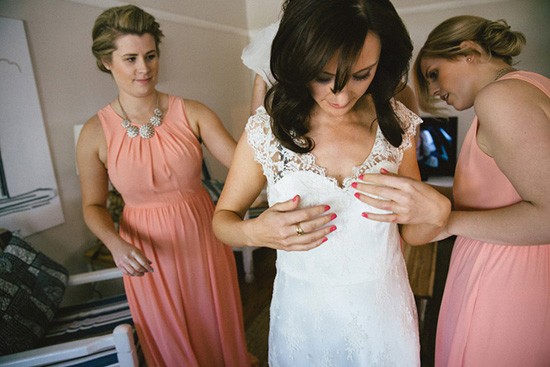 Bride in lace dress with peach bridesmaids