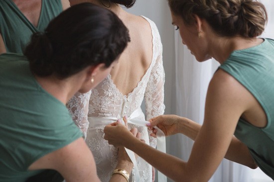 Tying bow on brides gown