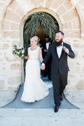 newlyweds in frotn of sandstone building