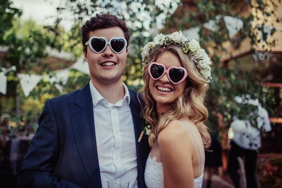 Bride and groom in heart sunglasses
