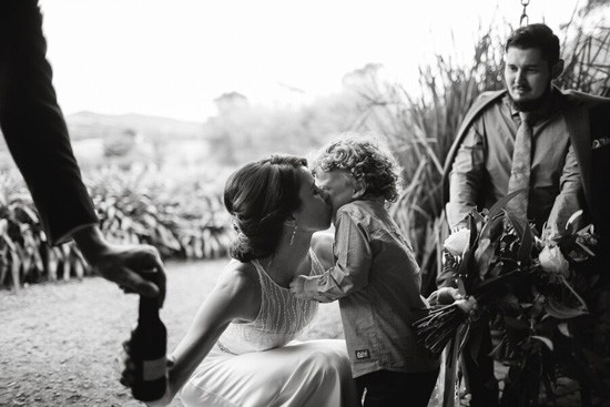 Bride kissing child after wedding