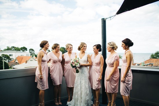 Bride with bridesmaids in pink draped dresses