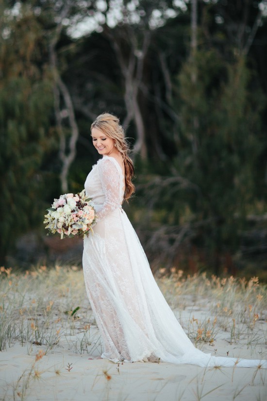 Bride with long sleeve gown at beach