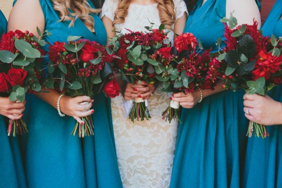Bridesmaids in teal with red bouquets