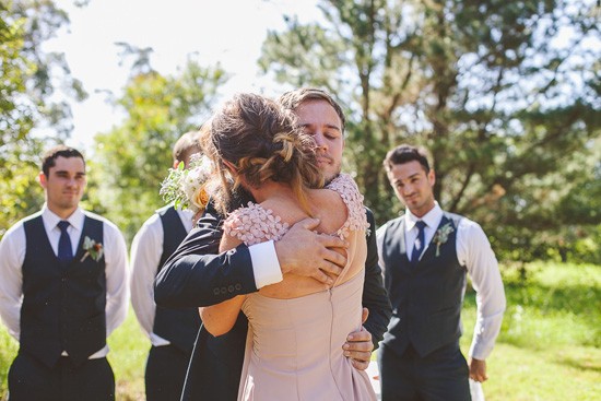 Groom hugging bridesmaid