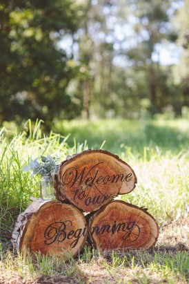 Welcome sign on logs for wedding