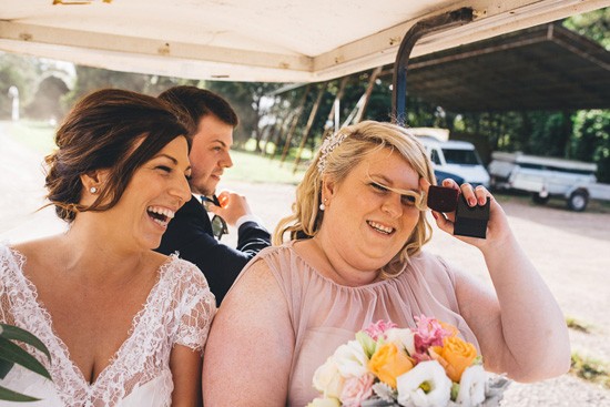 Bride and bridesmaid on gold cart