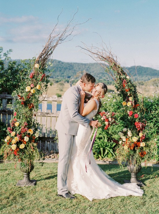 Bride and groom with floral arch