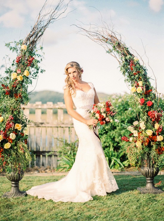 Bride in front of floral arch