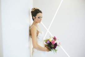 Bride in front of white wall with bouquet