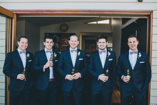 Groom and groomsmen in navy suits with bow ties