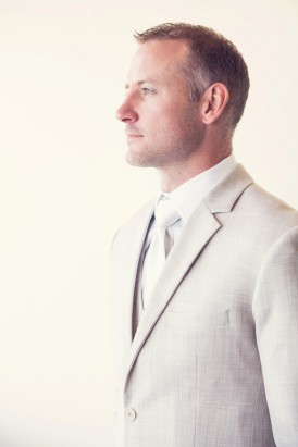 Groom in taupe suit with white tie