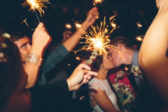 Kissing with sparklers at wedding