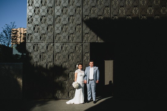 Bride and groom against textured wall