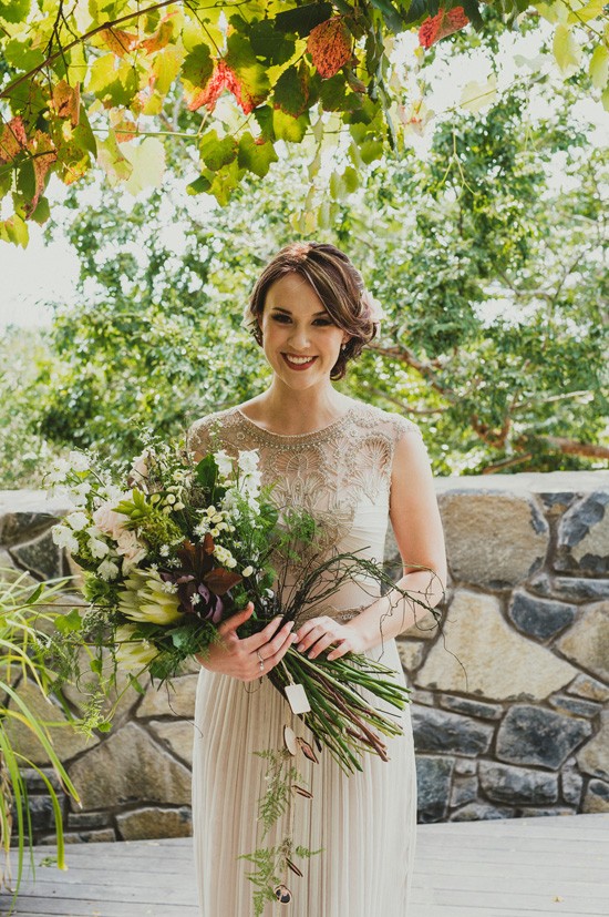 Bride in oyster gown with modern sheath bouquet