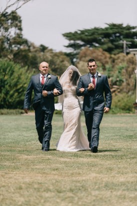 Bride walking down the aisle with brothers