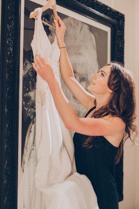 Bride with hanging wedding dress