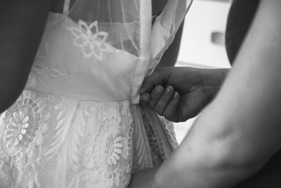 Bride zipping wedding gown