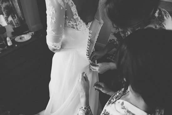 Buttoning brides wedding dress