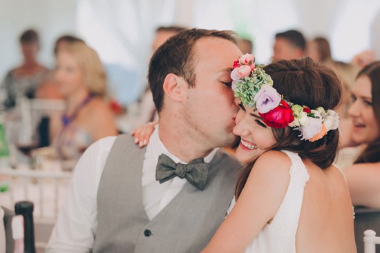 Groom kissing bride at reception