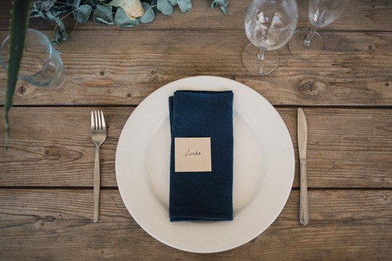 Navy navy on raw wood table at wedding
