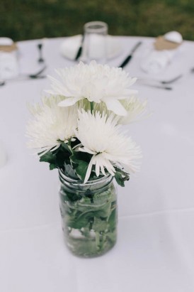 White flowers in glass jar wedding centrepiece