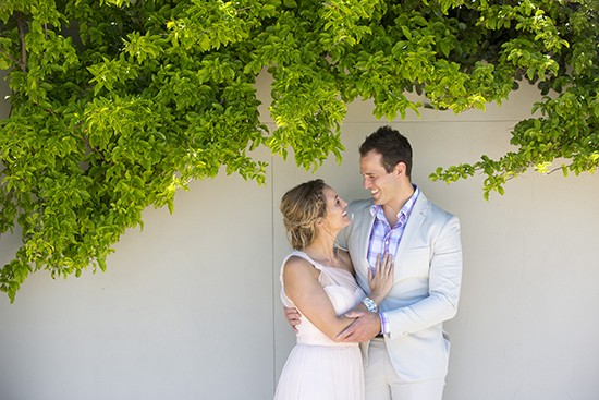 Engagement Photo againats a wall with green trees